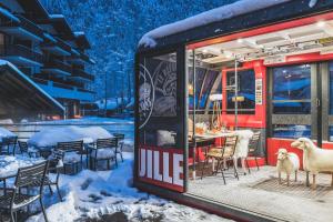 Due pecore in piedi di fronte a un ristorante nella neve di Hôtel Le Refuge des Aiglons a Chamonix-Mont-Blanc