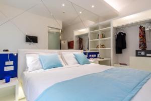 a bedroom with a large white bed with blue pillows at Hotel Nuovo Giardino in Rimini
