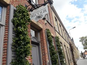 a sign for a restaurant on the side of a brick building at Guesthouse Recour in Poperinge