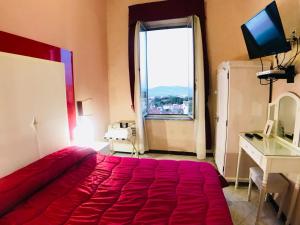 a bedroom with a large red bed and a window at Albergo Panorama in Frascati