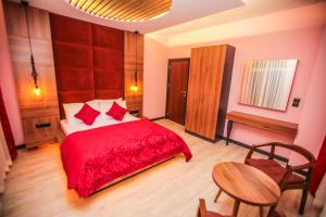 a bedroom with a red bed and a table at Borapark Otel in Erzurum