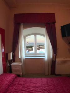 a bedroom with a bed and a large window at Albergo Panorama in Frascati