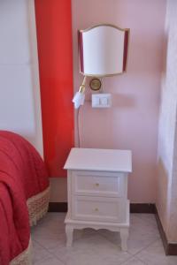 a white nightstand with a lamp next to a bed at Albergo Panorama in Frascati