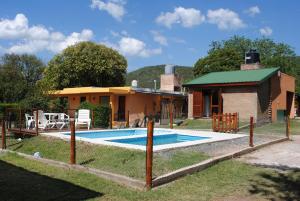 una casa con piscina frente a una casa en Complejo Nuestros Hijos en Villa Carlos Paz