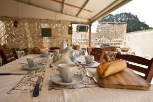 un tavolo con tazze da tè e un pane sopra di Vento Di Scirocco a Pozzallo