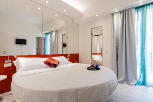 una camera da letto con un grande letto bianco e uno specchio di Hotel Nuovo Giardino a Rimini