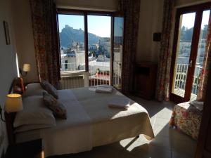 a bedroom with a bed and a large window at Hotel Europa in Ischia