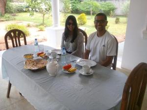 a man and woman sitting at a table with food at First House Mihintale in Mihintale