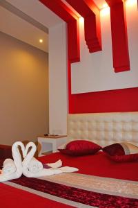 1 dormitorio con 1 cama roja y blanca y toallas en Monte Carlo Love Porto, en Oporto