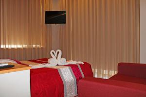 a red bed with a bow on top of it at Monte Carlo Love Porto in Porto