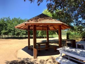a wooden pavilion with a picnic table and a bench at Quinta el Rosal in Parral