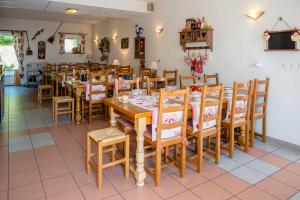 uma sala de jantar com mesas e cadeiras de madeira em gite de pontgibaud em Lathuile