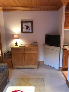 a living room with a television and a table with a lamp at Le Tremplin in Méribel