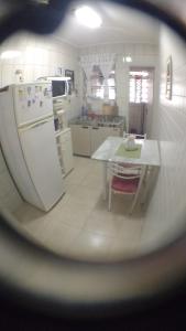 a kitchen with a refrigerator and a table in it at Apartamento Praia Santos in Santos