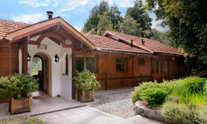 una pequeña casa de ladrillo con una entrada arqueada en Casa Fischer del Lago en San Carlos de Bariloche