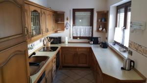 a kitchen with wooden cabinets and a sink at Haus Vor den Eichen für Familien in Willingen