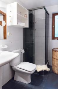 a white bathroom with a toilet and a shower at Casa Fischer del Lago in San Carlos de Bariloche