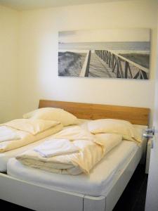 a bed in a bedroom with a painting on the wall at Haus zur Mole - Morgenstern in Großenbrode