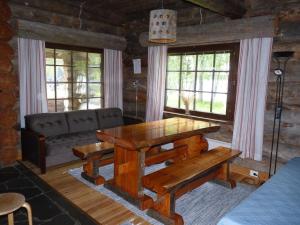 a living room with a wooden table and a couch at Karhujärven Kelopirtit in Karhujarvi
