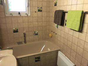 a bathroom with a tub and a toilet and a sink at Apartment Andy & Gabi in Neuhausen auf den Fildern