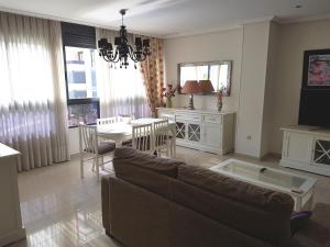 a living room with a couch and a table at GEMELOS 26 APARTMENTS - Benidormland in Benidorm