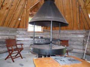 an old stove in a room with a table and chairs at Karhujärven Kelopirtit in Karhujarvi