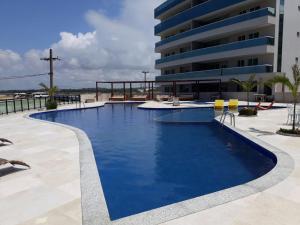 a swimming pool in front of a building at Apartamento Super Luxo em Arraial do Cabo in Arraial do Cabo