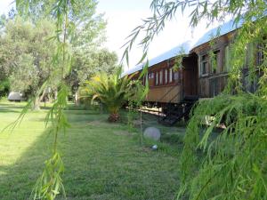 an old train car sitting in a yard at El Viejo Vagon 1908 in San Rafael