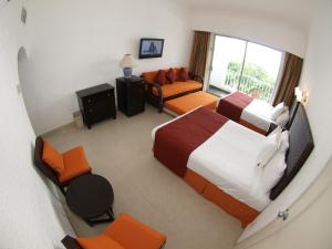 ein Hotelzimmer mit 2 Betten und einem Sofa in der Unterkunft Sierra Mar All Inclusive at Tesoro Manzanillo in Manzanillo
