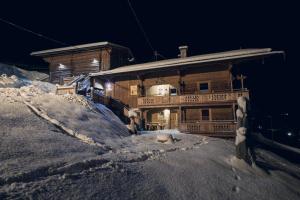 uma casa no topo de uma montanha coberta de neve em Joggelerhof em Finkenberg