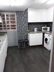 ベニドルムにあるLas Tejas46のキッチン(白いキャビネット、洗濯機、乾燥機付)