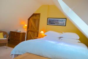 アンドーバーにあるEastfield House Lodgeの白いベッドと木製のドアが備わるベッドルーム1室が備わります。