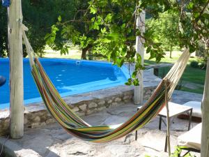 una hamaca frente a una piscina en Las Lomas, Casa de Campo en Villa Cura Brochero