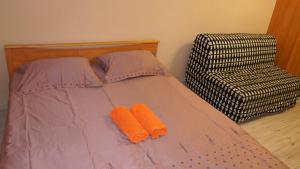 モスクワにあるApartments Presnenskiy Valのベッドと椅子に座ったオレンジ色のタオル2枚