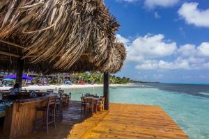 a bar on the beach with a straw umbrella and the ocean at X'tan Ha- The Waterfront in San Pedro