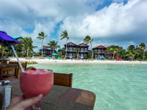 a person holding a drink in front of the beach at X'tan Ha- The Waterfront in San Pedro