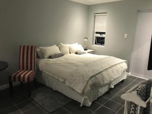 a bedroom with a large bed and a chair at Studio pool room in Hout Bay