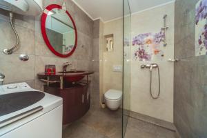 a bathroom with a shower and a sink and a mirror at Apartments Galija Petrovac Lux in Petrovac na Moru