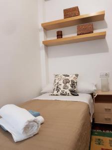 a bedroom with a bed with a pillow and shelves at Guillem Sorolla Apartment in Valencia