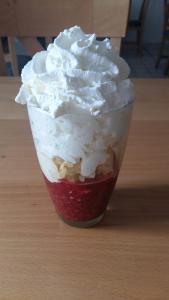 una bebida con crema batida en una taza roja sobre una mesa en RATOMAS, s.r.o. en Kostelec na Hané