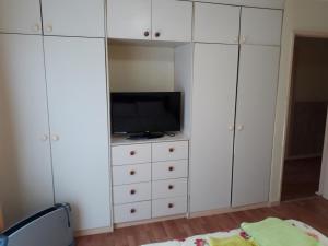 1 dormitorio con armarios blancos y tocador con TV en Casa Jardines del Mar, Puerto Montt en Puerto Montt