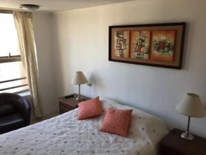 um quarto com uma cama com duas almofadas cor-de-rosa em Departamento Suke em Viña del Mar
