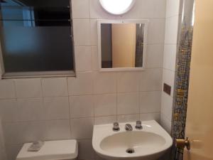a bathroom with a sink and a toilet and a window at Casa Jardines del Mar, Puerto Montt in Puerto Montt +15 photos