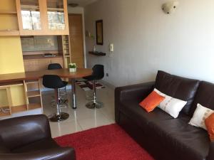 - un salon avec un canapé et une table avec des chaises dans l'établissement Departamento Suke, à Viña del Mar