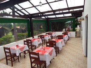 a row of tables and chairs in a restaurant at Pousada Chalés da Felicidade in Itu