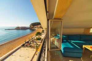 a living room with a couch and a view of the beach at Apartments Galija Petrovac Lux in Petrovac na Moru