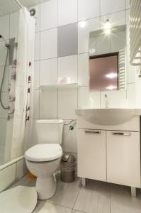 a white bathroom with a toilet and a sink at Bubble Apartments in Kraków