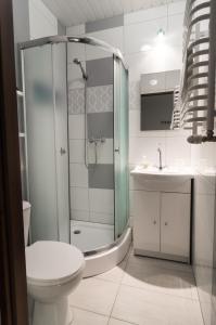een badkamer met een douche, een toilet en een wastafel bij Bubble Apartments in Krakau