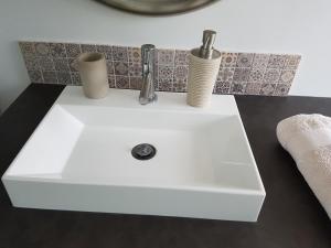 a white sink with a faucet on top of it at Fontainebleau Sweet Home Duplex in Fontainebleau +14 photos