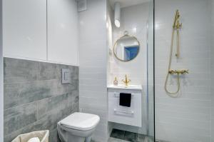 y baño con aseo, lavabo y ducha. en Modern Place Apartament przy plaży, en Gdynia